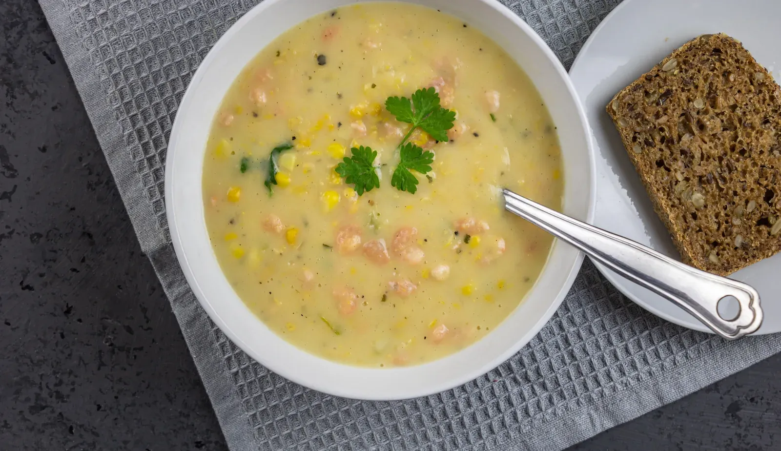Teller mit frisch gekochter Suppe und einer Scheibe Vollkornbrot